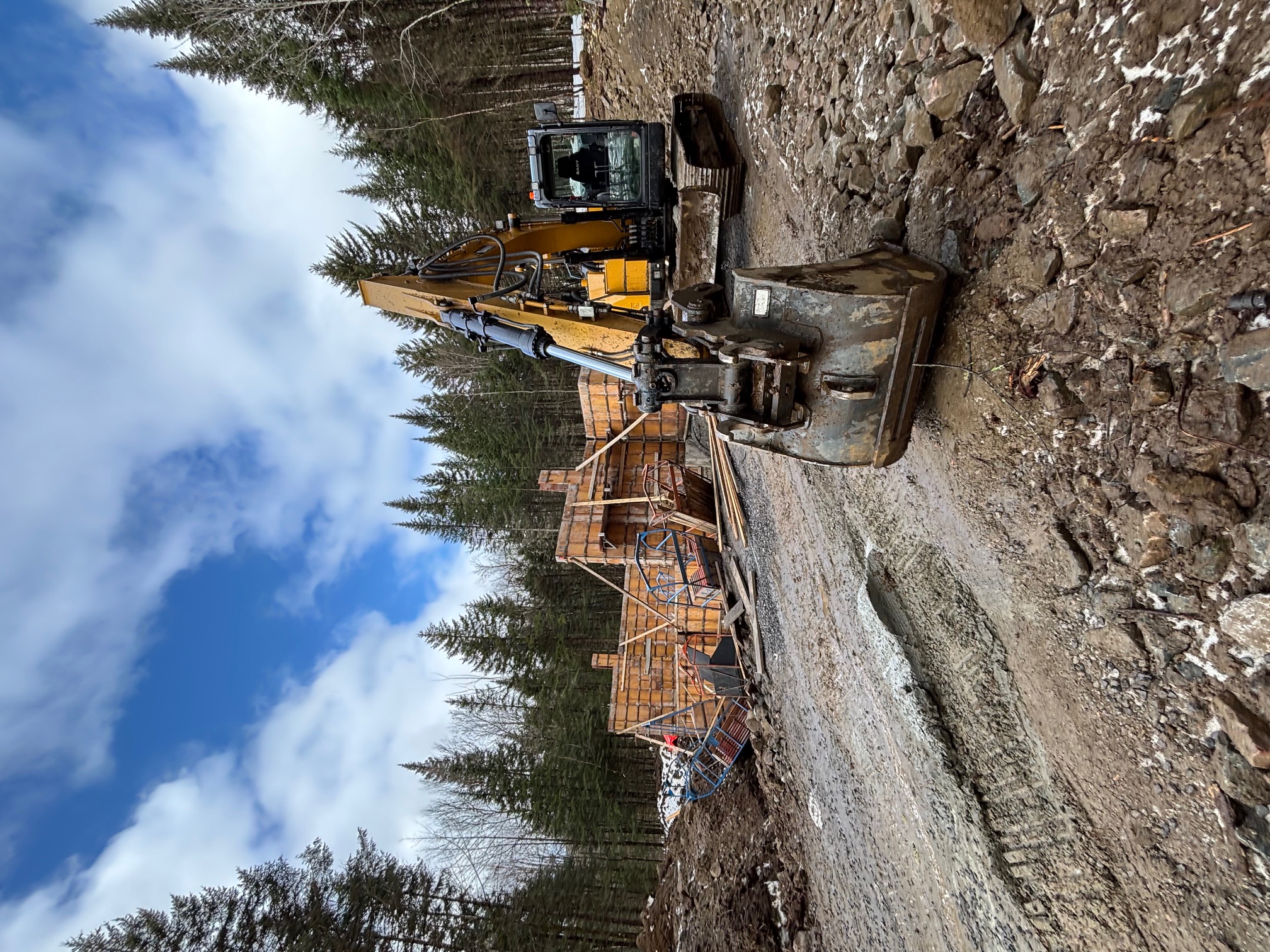Construction de fondation en béton pour maison neuve sur un chantier en milieu boisé à Beaupré