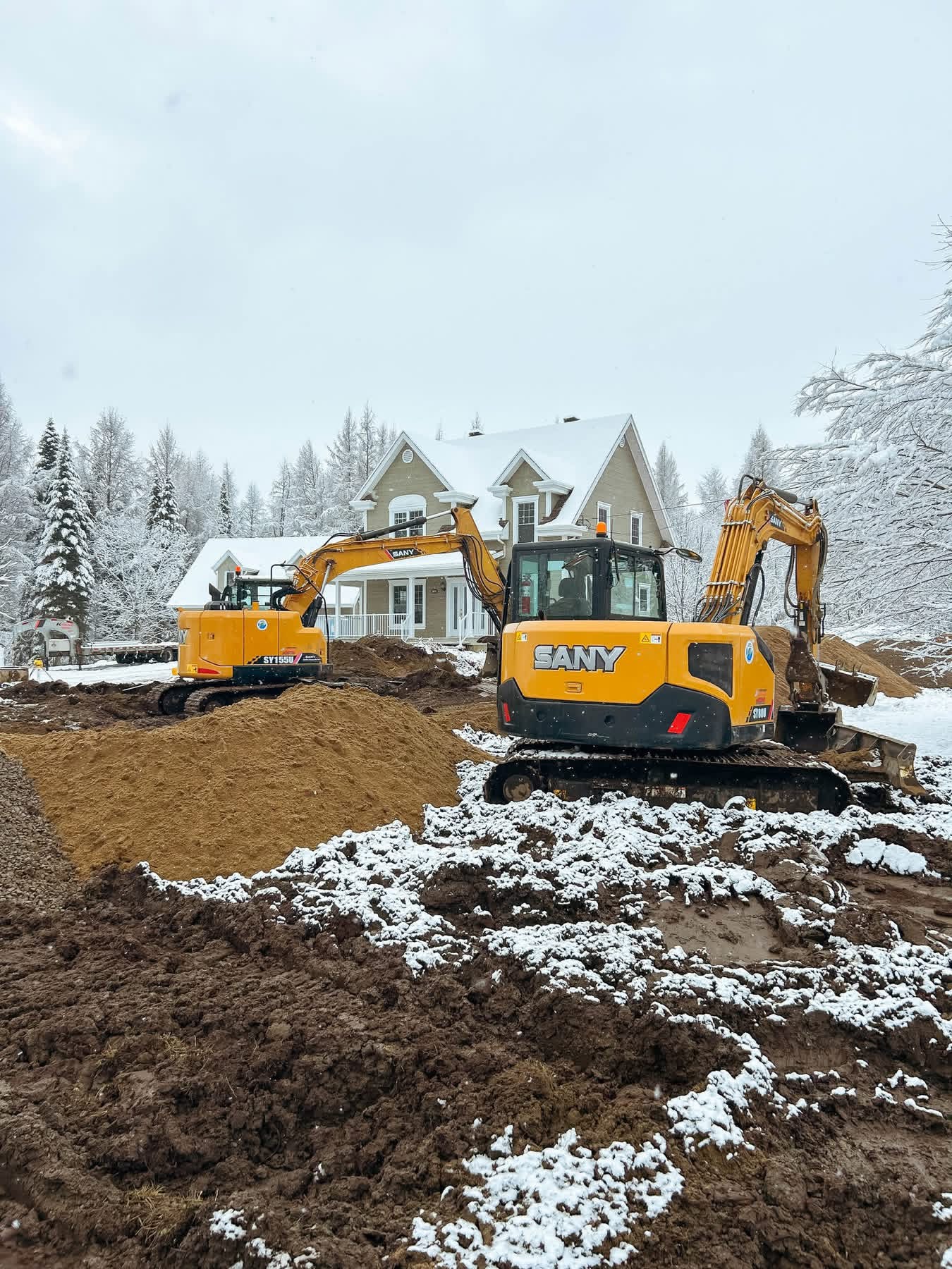 Travaux d’excavation de terrain avec machinerie lourde sur un chantier résidentiel en hiver région de Québec