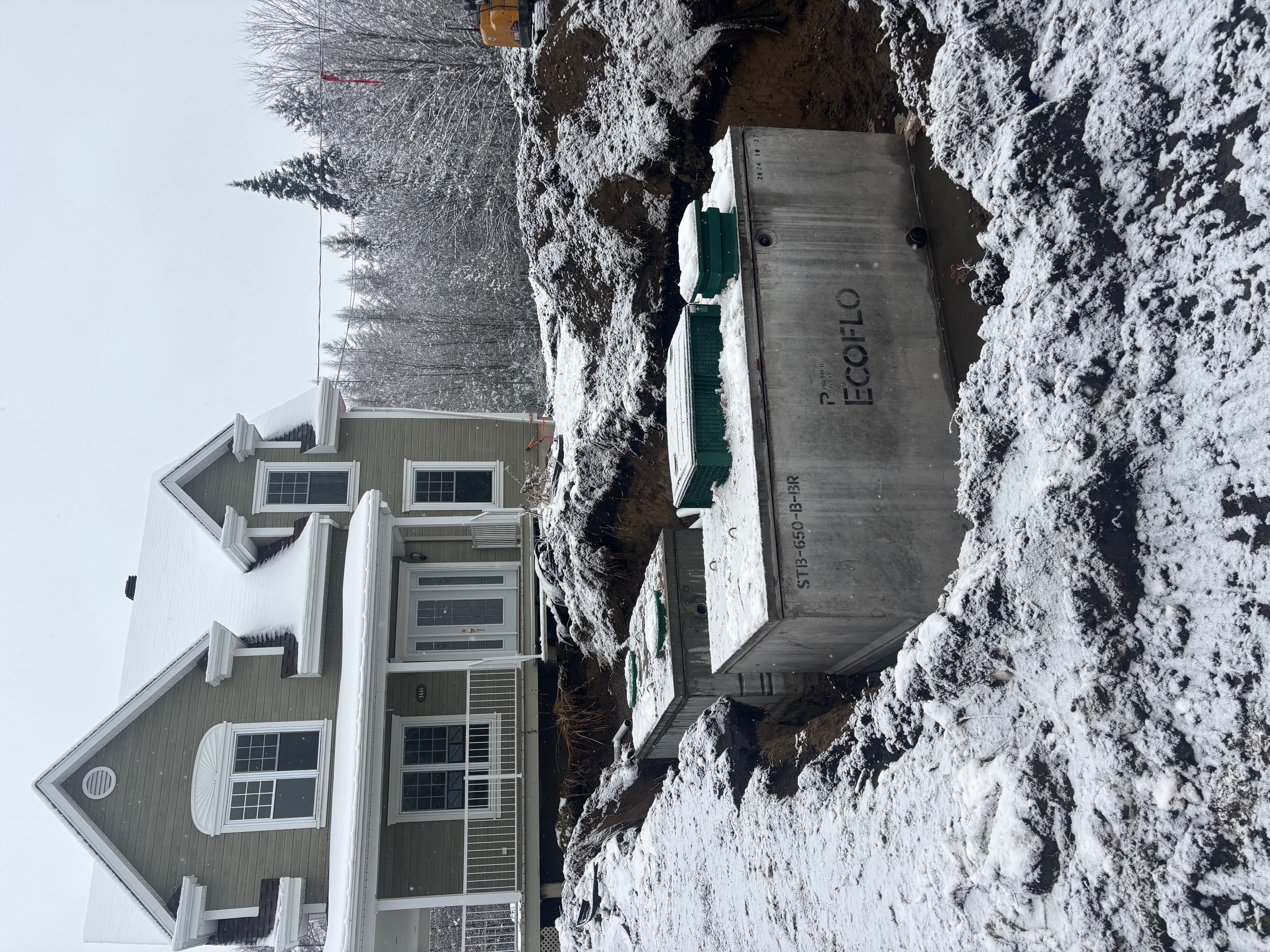 Installation d’une fosse septique ECOFLO devant une maison en hiver avec excavation du terrain à Québec